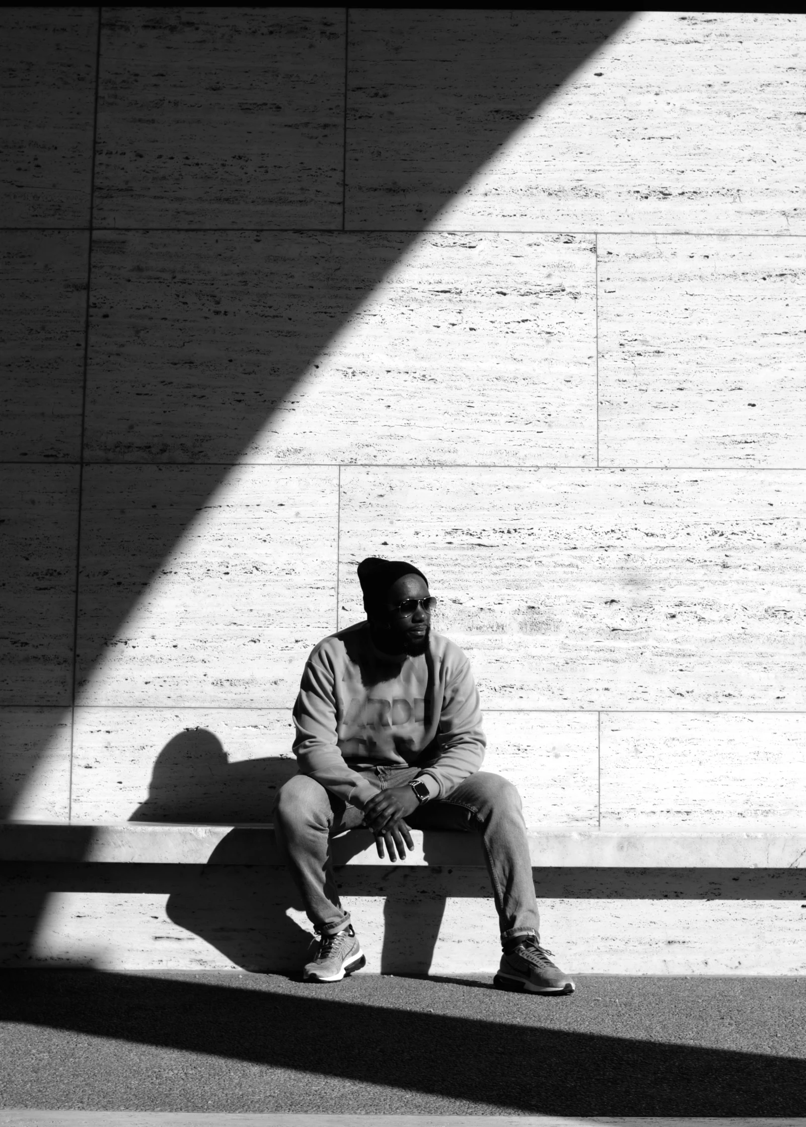 black and white pograph of a man sitting on a bench