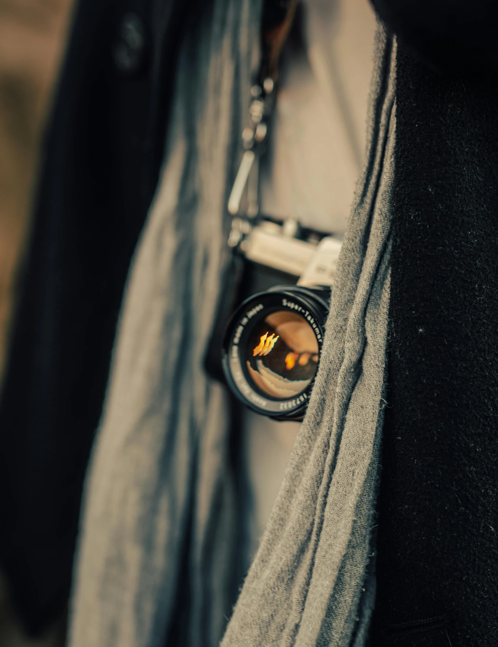 the reflection of someone with their camera in his pocket