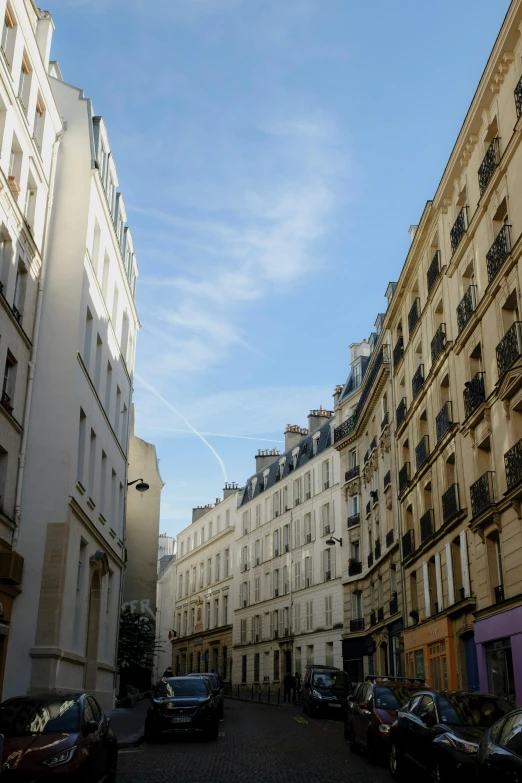 many cars are parked in an old street