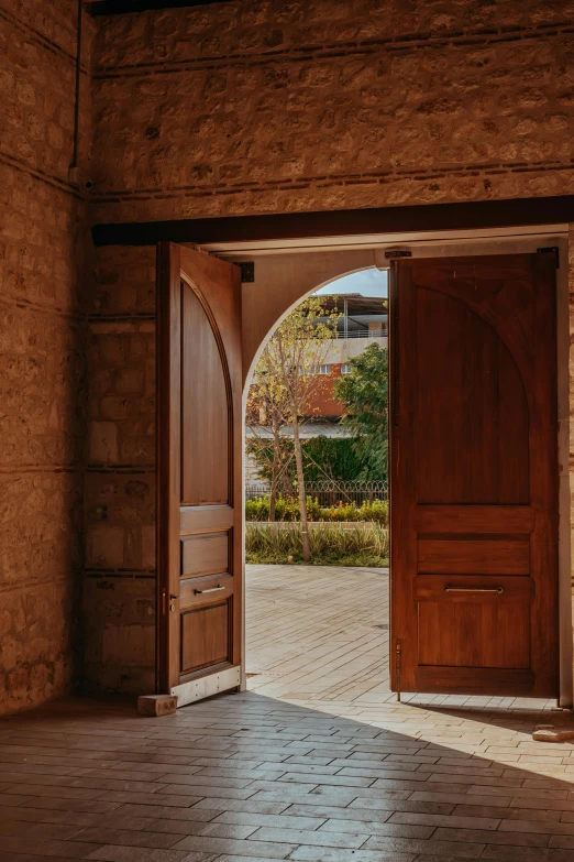 an empty room with double doors opened and tile floors