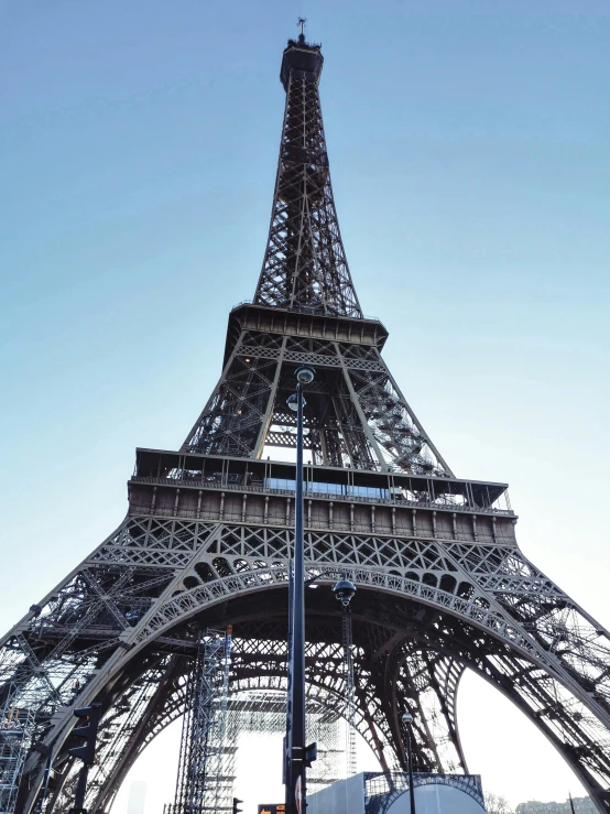 a tall silver metal tower with a flag on top of it