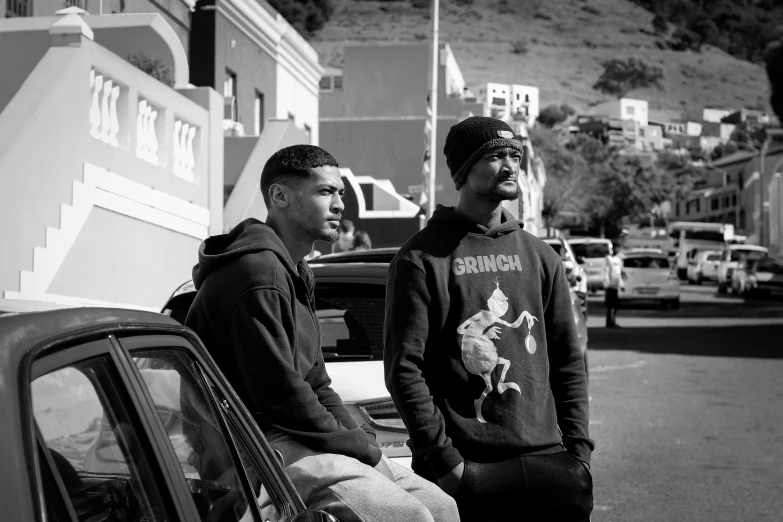 two men that are sitting on the back of a car