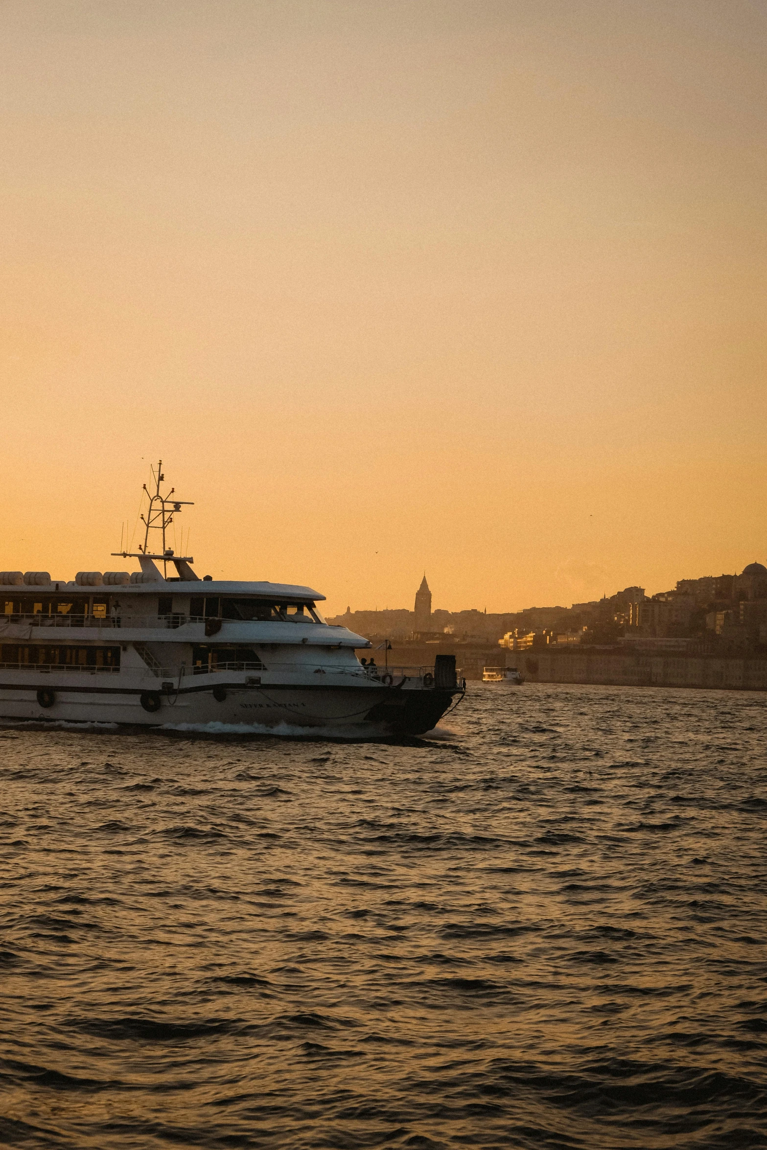 two boats at dusk on the water and one is anchored