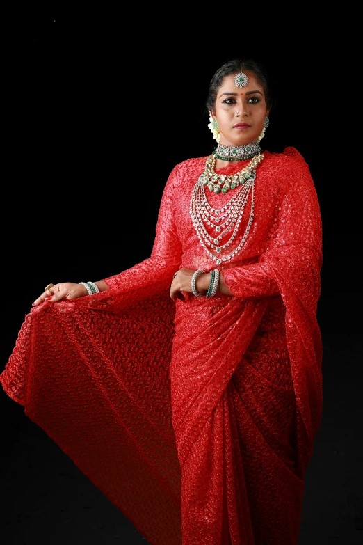 woman in a red and gold indian saree with pearls