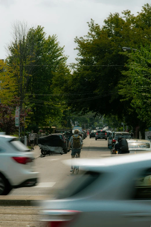 people ride in cars and walk through the city