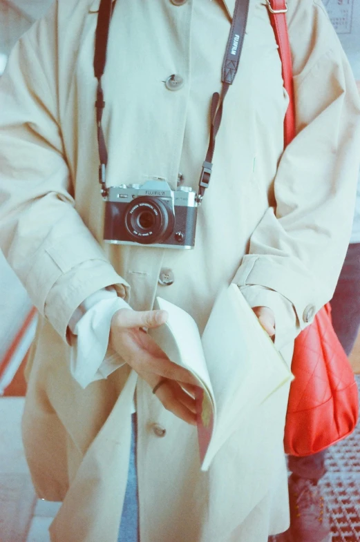 a man holding a book and camera in his hands