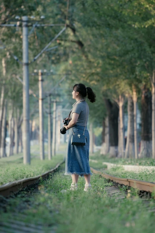 a woman standing in the train tracks