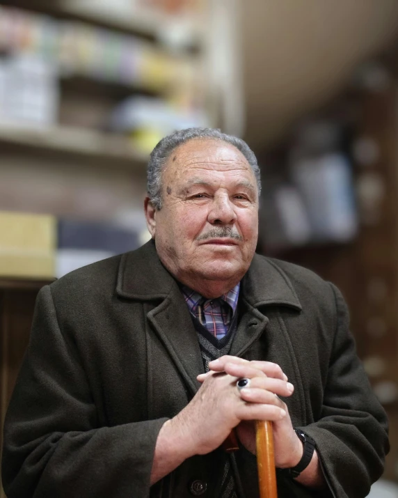 man with hat and mustache wearing a coat in a pharmacy