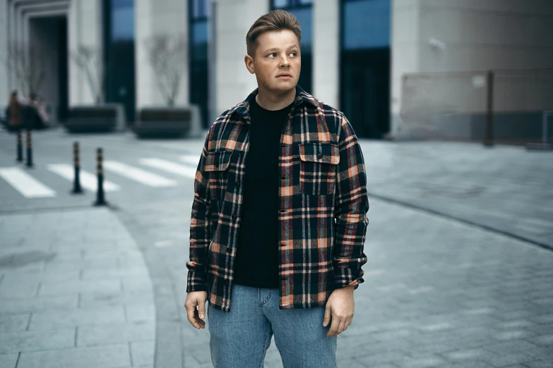 a man in a jacket standing on a street corner