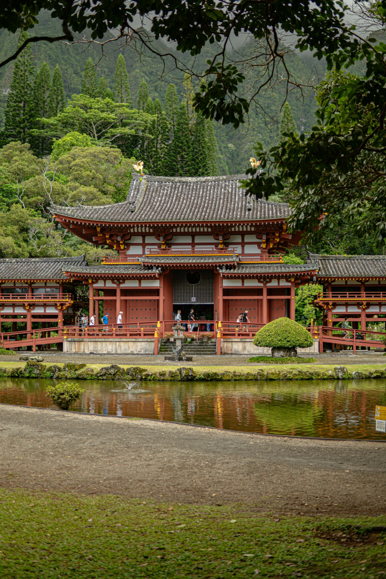 people sitting at a bench in the background of a building with water surrounding