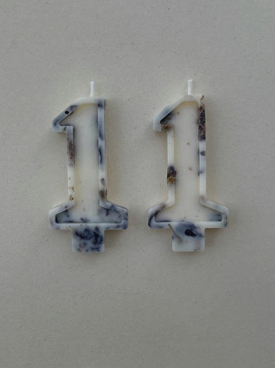 two marble numbers on white wall