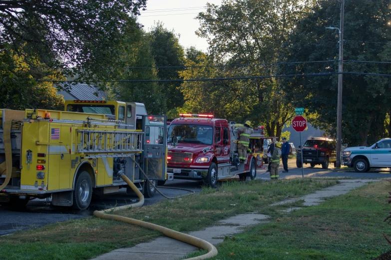 two fire trucks with their hoses out in front of them