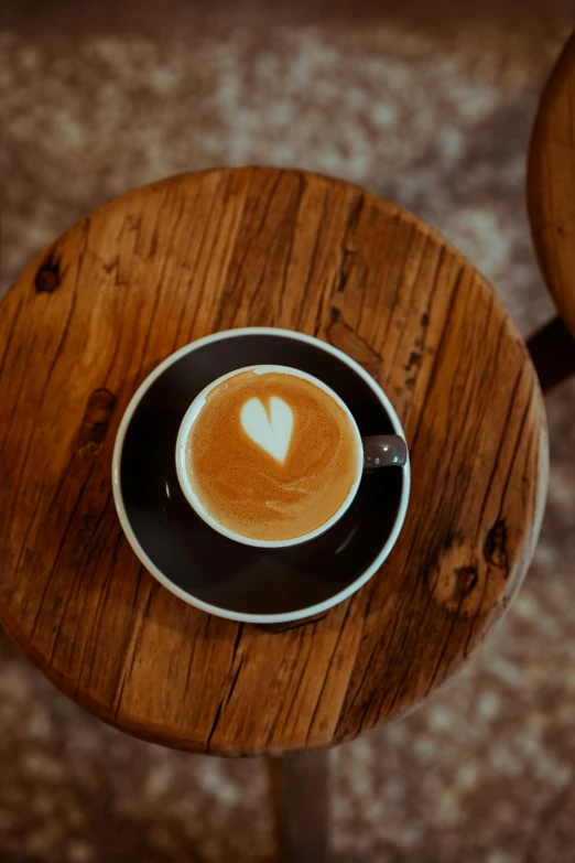 a cappuccino is on top of a table in front of a chair