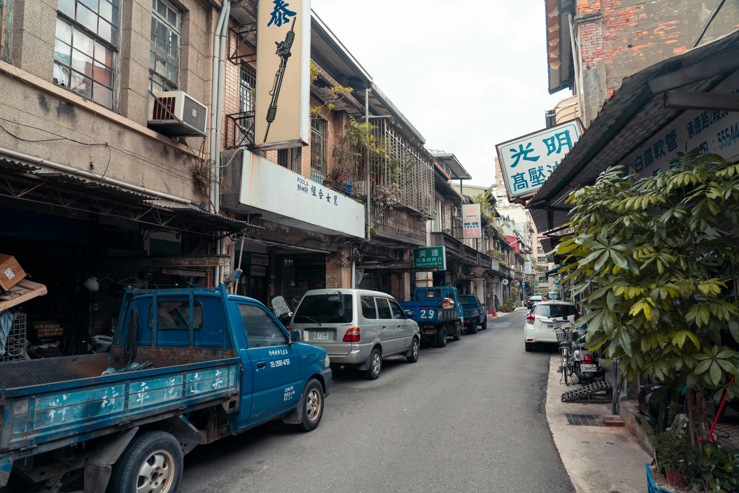 an asian street is filled with old and newer vehicles