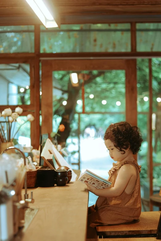 a  sitting at a table with a book