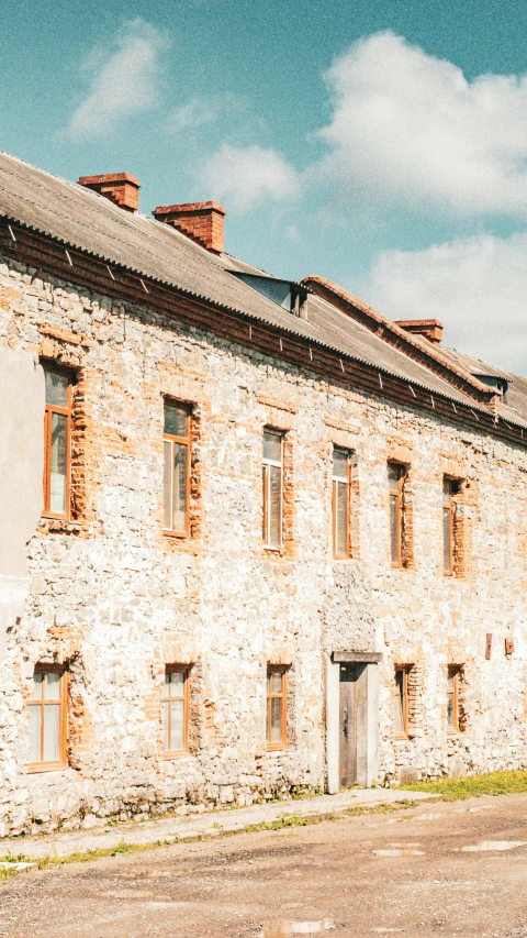 a stone building with orange shutters next to it