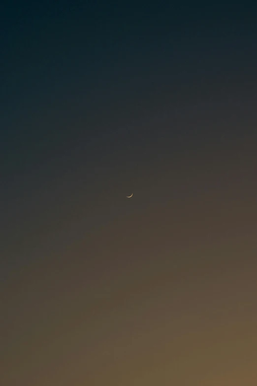 an airplane flying away with the moon and venus behind it