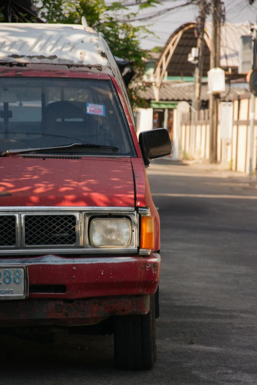 a small red truck with no doors parked on a street