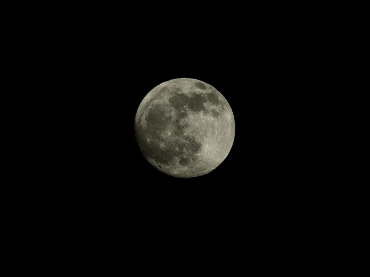 a full moon taken from a distance, against a dark background