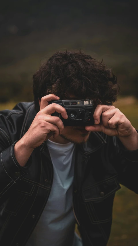 the man in black jacket takes pictures of his camera