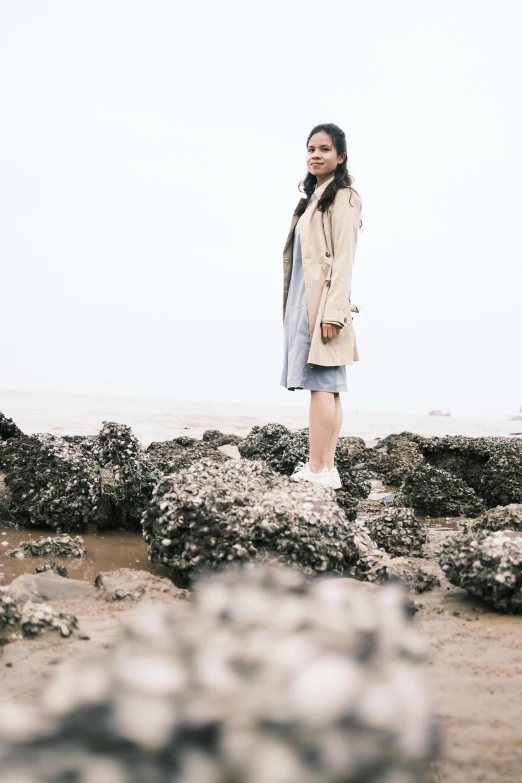 a person is standing on some rocks by the water