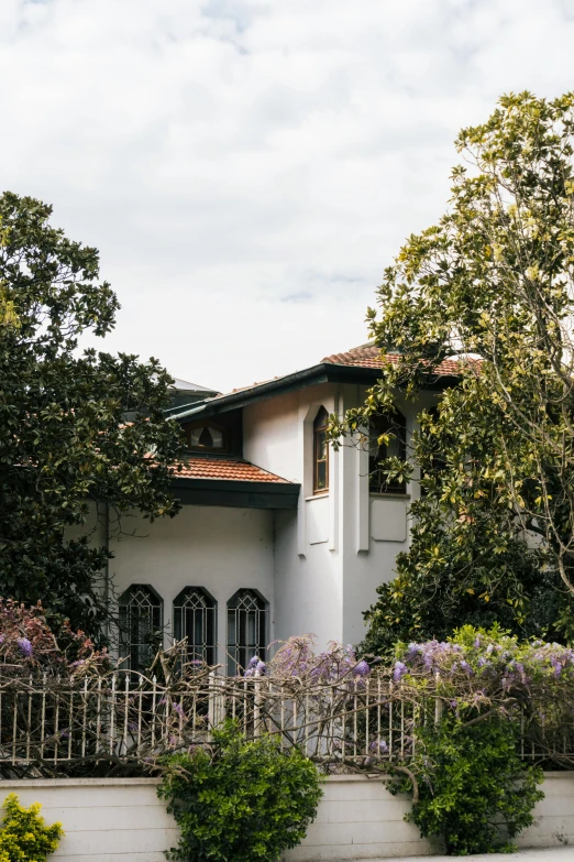 an ornate white house with flowers in the foreground