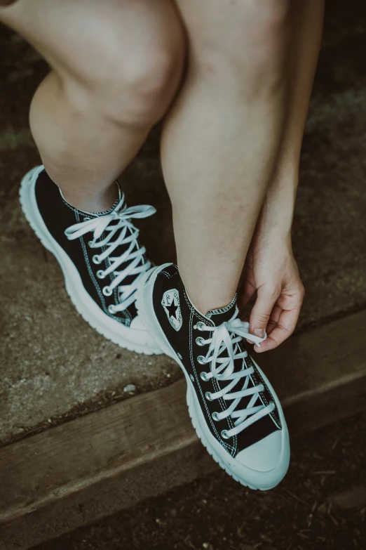 a woman is wearing black and white shoes