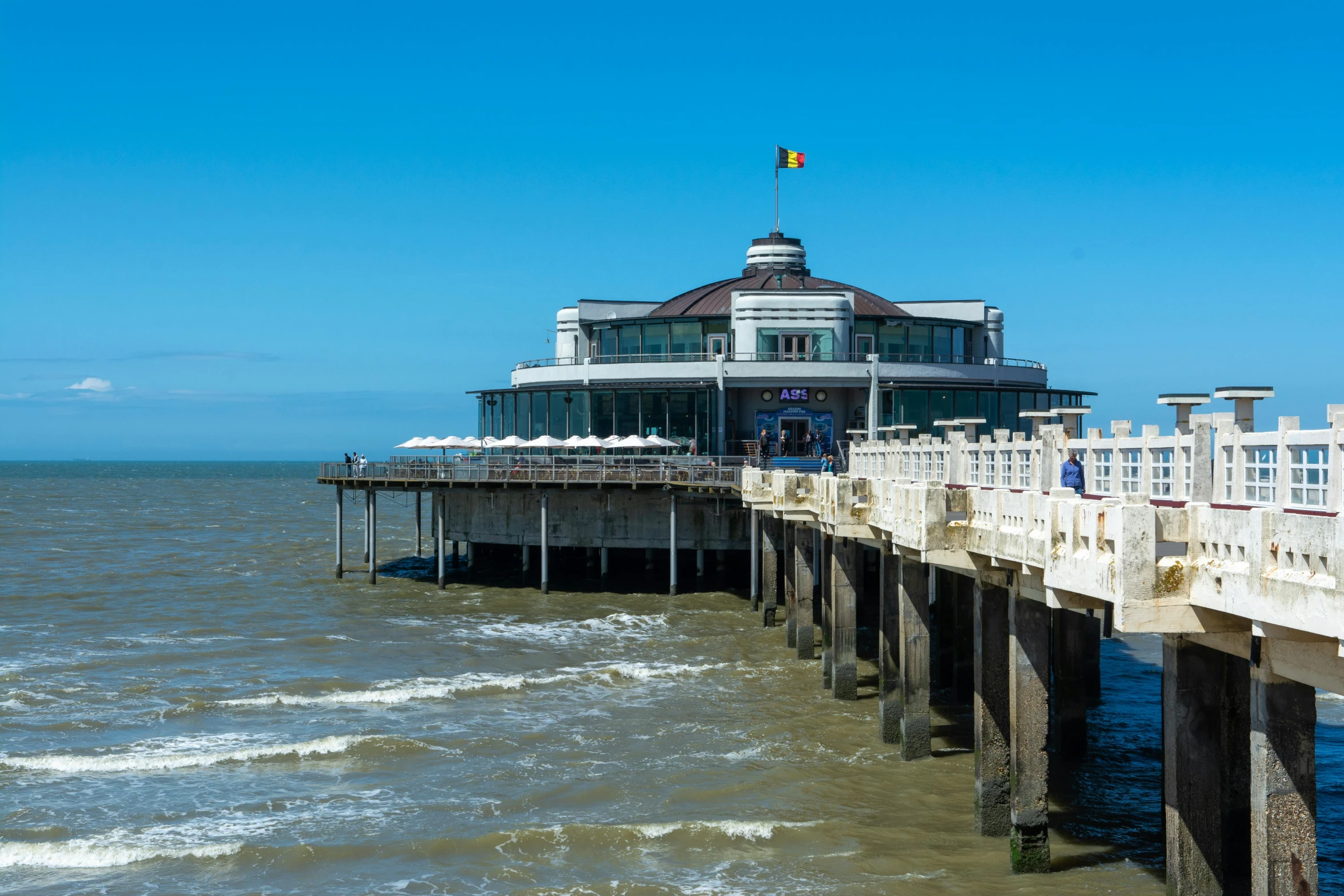 a pier at the top of the ocean next to an open water area