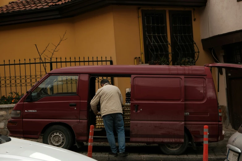 a man with a white helmet walking toward a van