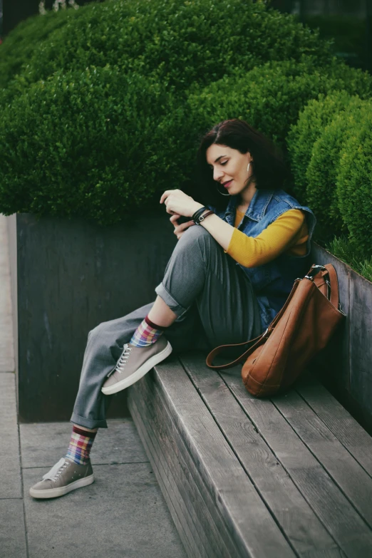 the woman is sitting on a wall reading soing