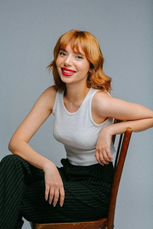 woman with red lips sitting on a chair smiling