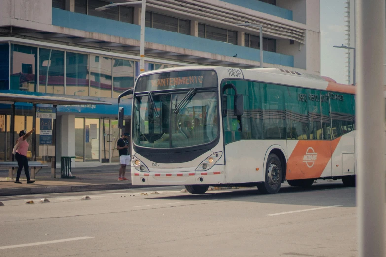 a bus on a street with people waiting to board