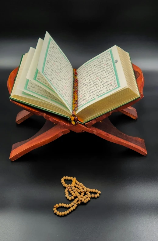 a book and beads on top of a wooden stand