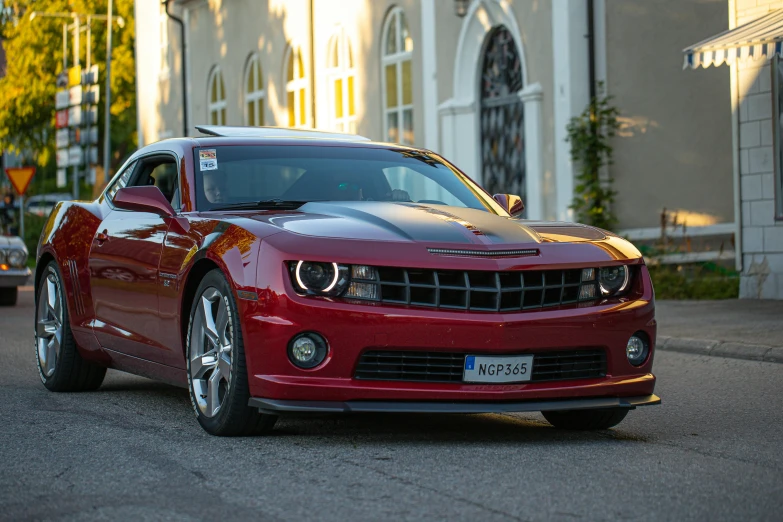 a red chevrolet car driving through an intersection