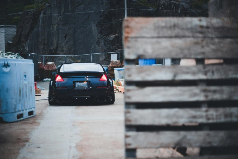 a black car driving down the road near a wooden crate