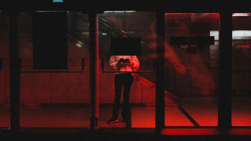 a woman standing outside in the dark with an umbrella