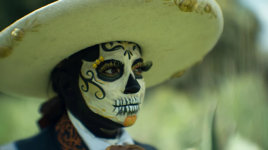 a man wearing a sombrero and a skull painted in black and orange