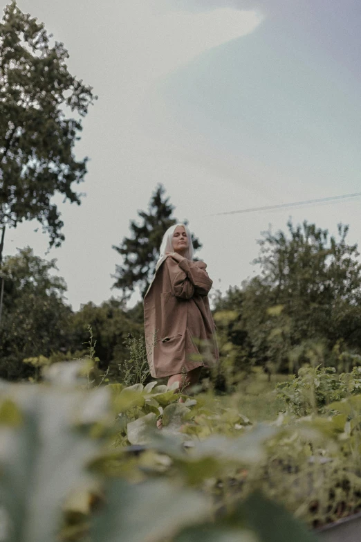 a woman in a trench coat is walking away