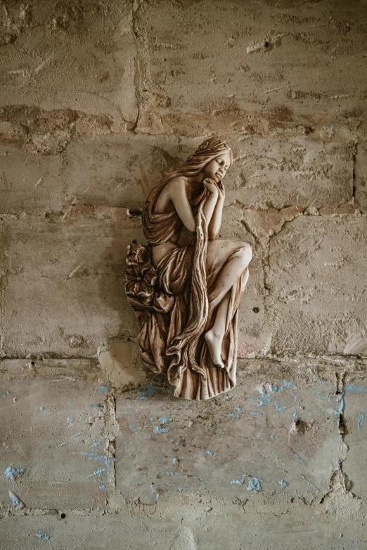 a statue is lying on the ground near rocks