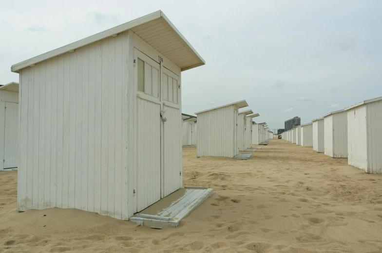 a small white shed stands in the sand
