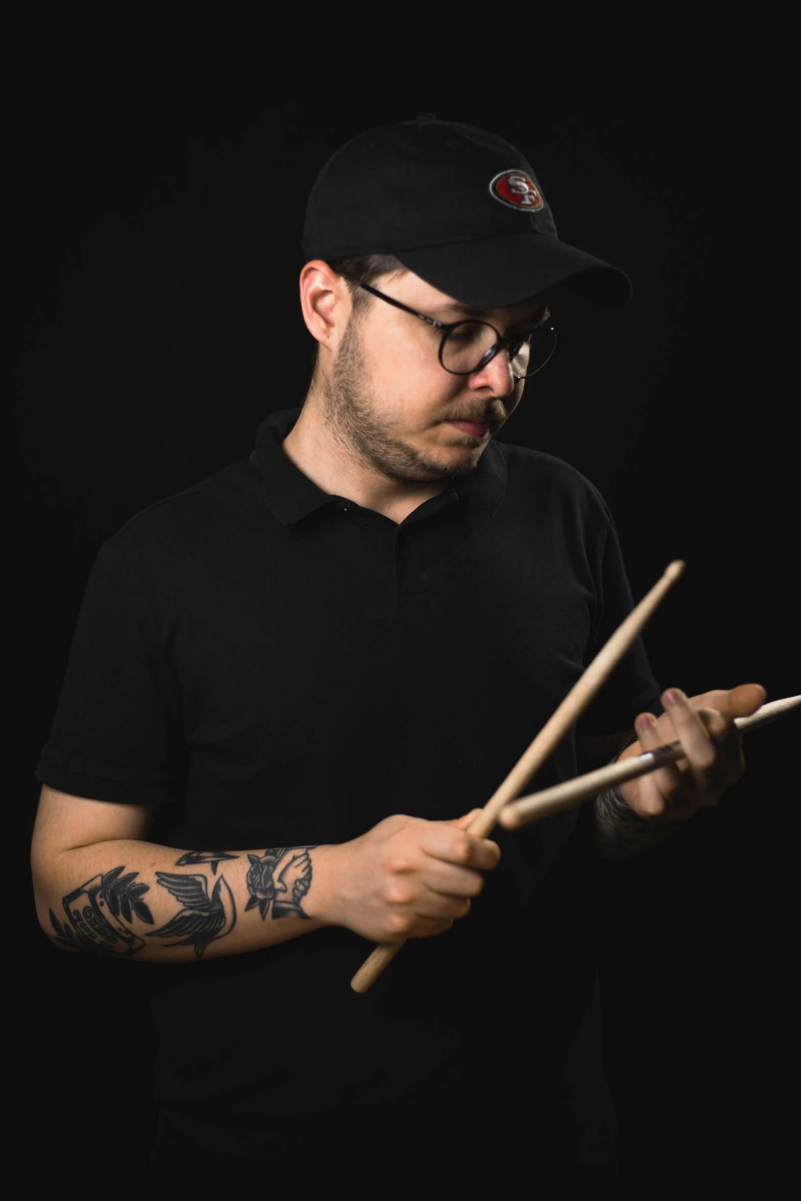 a man holding two sticks and touching them on the handle of his drum stick