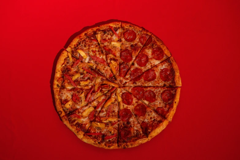 a sliced pizza on top of a red surface