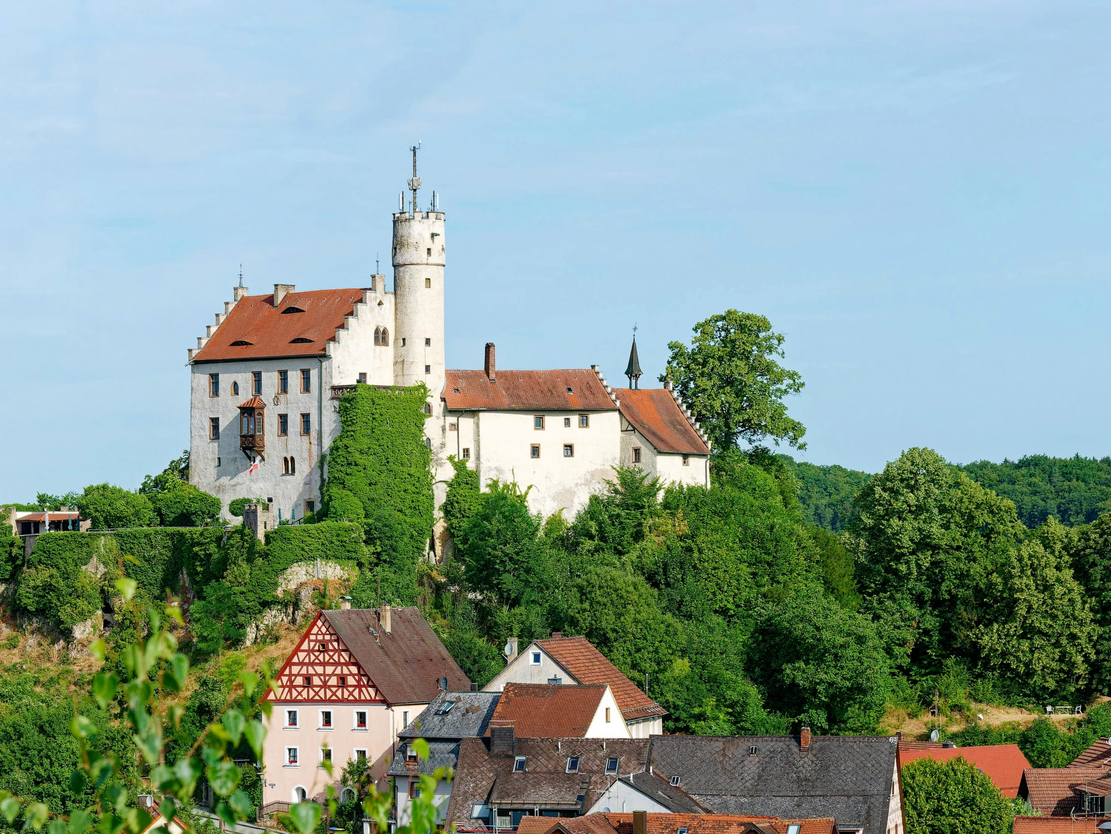 an old white castle is perched on top of a hill