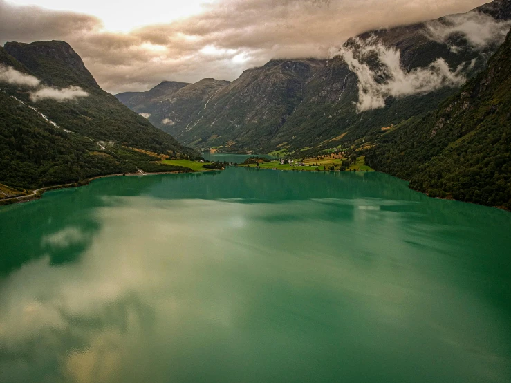 an aerial view of mountains and the green waters