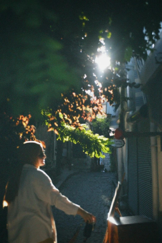 an old woman is walking down the street at night