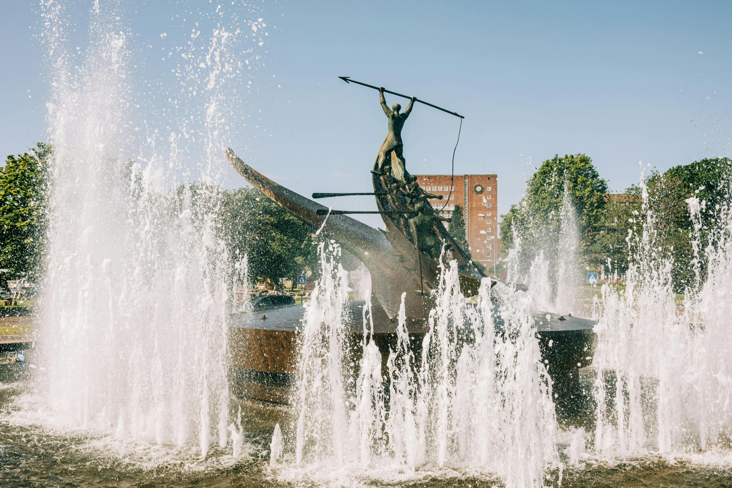 two water hoses spewing out water around a statue