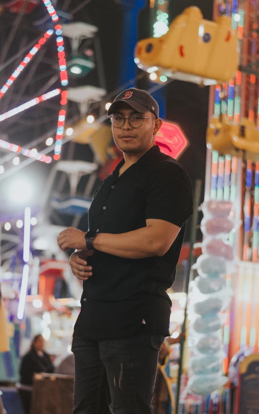 a man standing in a carnival park at night