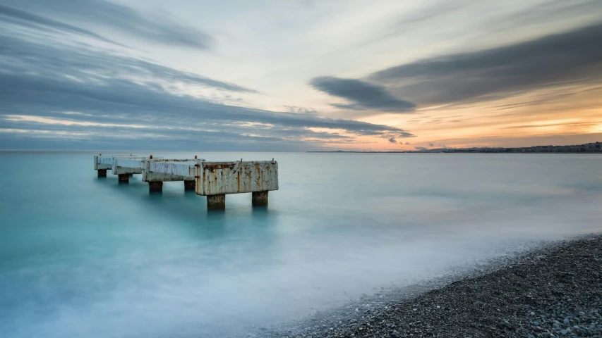 two old wooden docks sitting on top of the ocean