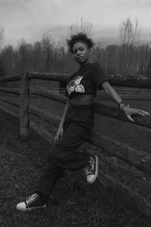 the girl is leaning on the wooden fence