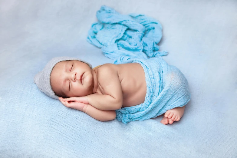 a baby laying on top of a blanket in blue